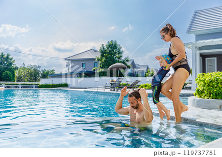 Happy vacation kid boy with family parent have fun enjoy at swimming pool. father and mother with son cheerful activity relaxing in summer holiday. 119737781