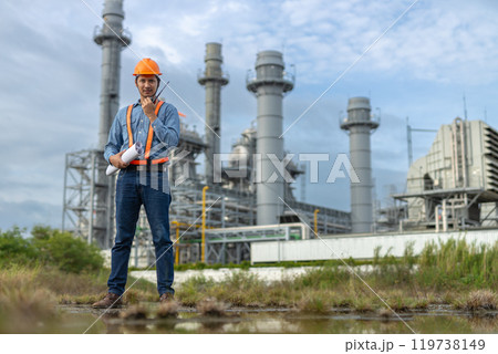 Man engineer talking with walkie-talkie working factory producing electricity oil. Construction manager oil refinery in petrochemical. improvement inspector Industrial worker working power plant. 119738149