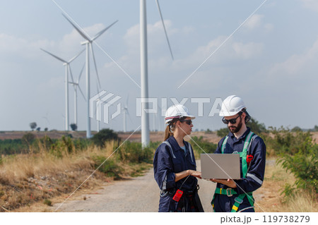 Team engineer wearing safety uniform holding laptop discussed plan about renewable energy at station energy power wind. technology protect environment reduce global warming problems. Team engineer wearing safety uniform holding laptop discussed plan about renewable energy at station energy power wind. technology protect environment reduce global warming problems. 119738279