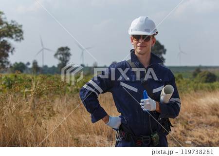 man engineer worker wearing safety uniform holding and reading blueprint working about renewable energy at station energy power wind. technology protect environment reduce global warming problems. man engineer worker wearing safety uniform holding and reading blueprint working about renewable energy at station energy power wind. technology protect environment reduce global warming problems. 119738281