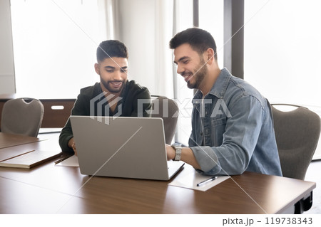 Two positive young male Middle Eastern entrepreneurs working on project 119738343