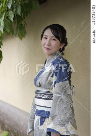 壁に立つ若い浴衣の女性 119738485
