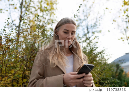 A businesswoman checks her phone near a business center A businesswoman checks her phone near a business center 119738838