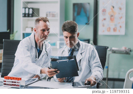 Group of medical practitioners working together and analyzing medical scan in the hospital Group of medical practitioners working together and analyzing medical scan in the hospital 119739331
