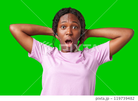 Woman expressing surprise and excitement on a bright green background 119739482