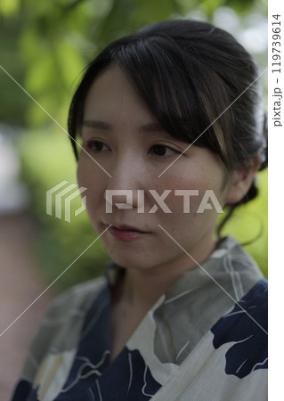 緑の木の葉に立つ若い浴衣の女性 緑の木の葉に立つ若い浴衣の女性 119739614