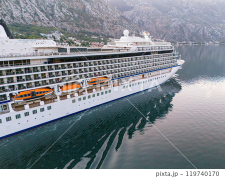 A cruise ship sails past against a rocky shore A cruise ship sails past against a rocky shore 119740170