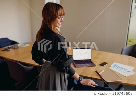A Professional Woman Working in a Modern Office Setting Surrounded by Advanced Technology A Professional Woman Working in a Modern Office Setting Surrounded by Advanced Technology 119745605