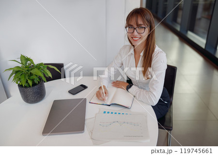 A Professional Woman Engaged in Her Work Within a Modern Office Environment Setting A Professional Woman Engaged in Her Work Within a Modern Office Environment Setting 119745661