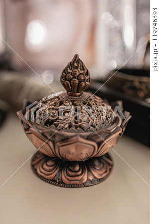 A beautifully crafted copper incense burner shaped like a lotus flower. Perfect for creating a serene and relaxing atmosphere, this piece is adorned with intricate designs and would make a stunning A beautifully crafted copper incense burner shaped like a lotus flower. Perfect for creating a serene and relaxing atmosphere, this piece is adorned with intricate designs and would make a stunning 119746393