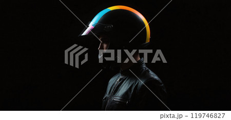 Conceptual depiction of a motorcyclist wearing a colored motorcycle helmet in a very dark and accentuated visual language - ai generated 119746827