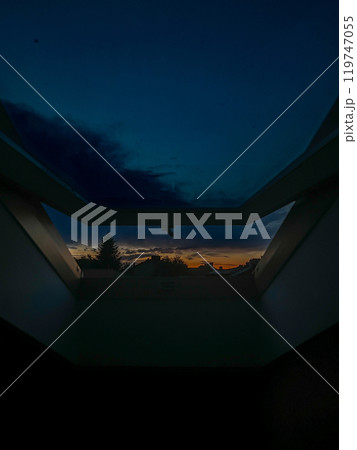 Sunset from the roof of a modern house in the evening through the open window. Sunset from the roof of a modern house in the evening through the open window. 119747055