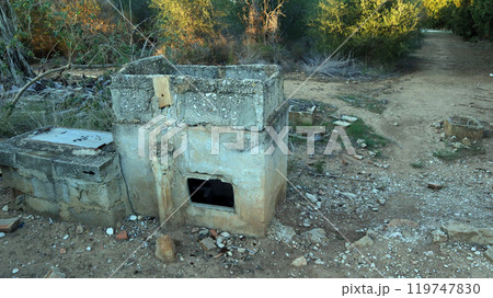 Abandoned stove remnants from a destroyed house in a rural area, surrounded by overgrown foliage and debris Abandoned stove remnants from a destroyed house in a rural area, surrounded by overgrown foliage and debris 119747830