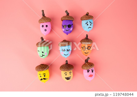nine acorns painted in various colors with different facial expressions drawn on them, 119748044