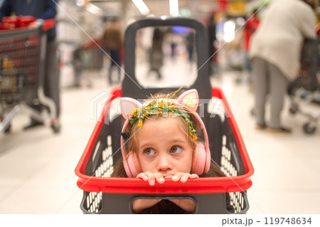 Bored girl wearing headphones while sitting in 119748634