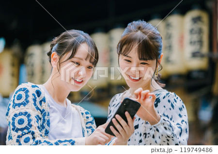 大阪観光で友達とスマホを見る女性 119749486