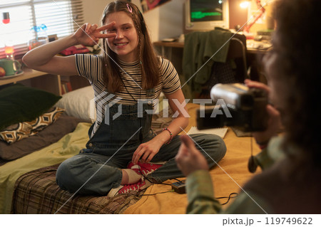 Smiling Teenager Posing Peace Sign Sitting on Bed Smiling Teenager Posing Peace Sign Sitting on Bed 119749622