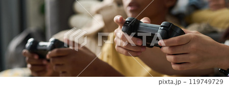 Enjoying Gaming Session with Friends Holding Controllers 119749729