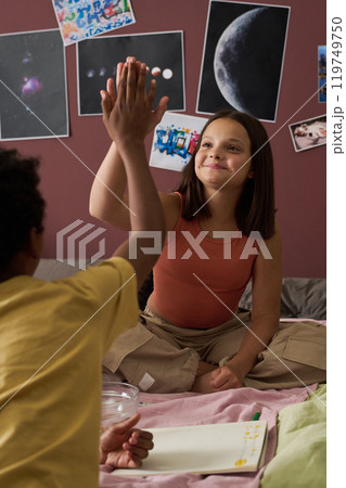 Children High-fiving While Studying Space Themed Posters Children High-fiving While Studying Space Themed Posters 119749750