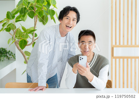 リビングでスマホを操作するシニア男性 119750502