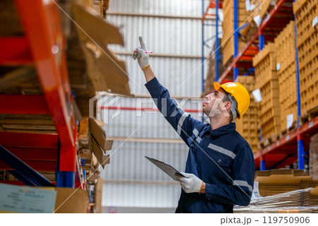 man paper warehouse worker using clipboard checking inspecting quality cardboard corrugated carton in storage. Large industry in paper product line manufacturing. man paper warehouse worker using clipboard checking inspecting quality cardboard corrugated carton in storage. Large industry in paper product line manufacturing. 119750906
