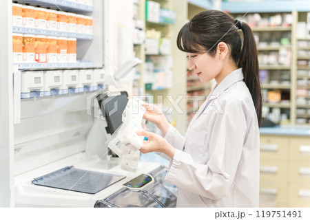 薬局・ドラッグストアで自動分包機を使って粉薬・調剤・処方箋を作る薬剤師 薬局・ドラッグストアで自動分包機を使って粉薬・調剤・処方箋を作る薬剤師 119751491
