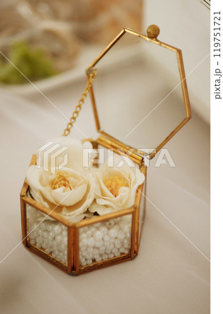 White fresia flower and gift box with diamond ring on color background, top view 119751721