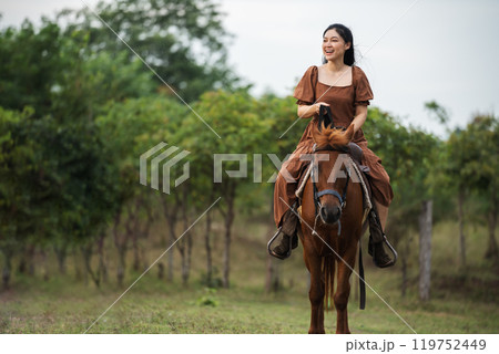 happy woman riding horse on meadow field 119752449
