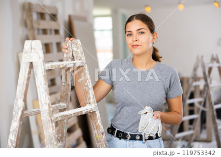 Portrait of woman worker standing in apartment Portrait of woman worker standing in apartment 119753342
