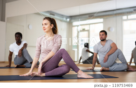 Woman and men practising lord of the fishes pose 119753469