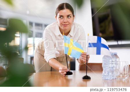female assistant prepares conference room for diplomats of Finland and Sweden 119753476