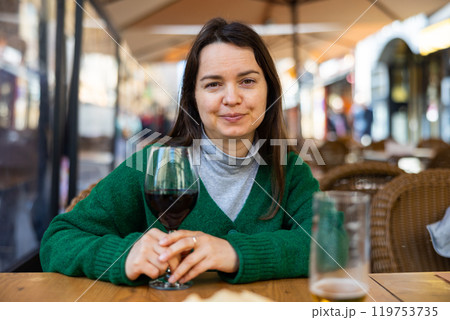 Young adult woman drinking wine at restaurant Young adult woman drinking wine at restaurant 119753735