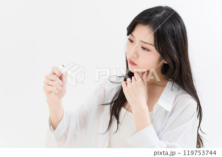 体温計を見ている若い女性 119753744