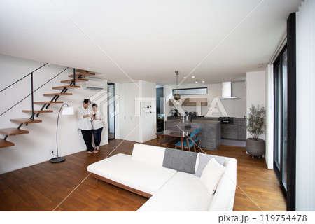 スマホを見る夫婦　リビング　スケルトン階段、人物、日本人、リビング 119754478
