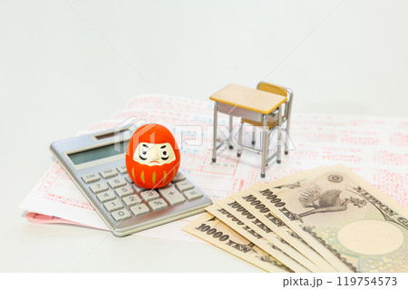 教育費 学費 お金のイメージ ダルマ、計算機、銀行の振込用紙、学校机とイス、一万円札 119754573