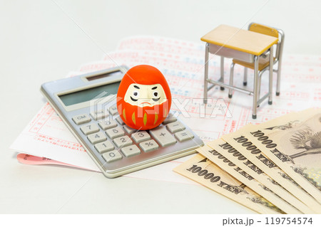 教育費 お金のイメージ ダルマ、計算機、銀行の振込用紙、学校机とイス、一万円札 119754574