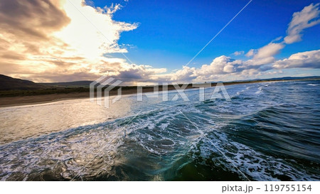 Low and high-speed FPV flight over a beach and the ocean water - The tranquil ocean waves are 119755154