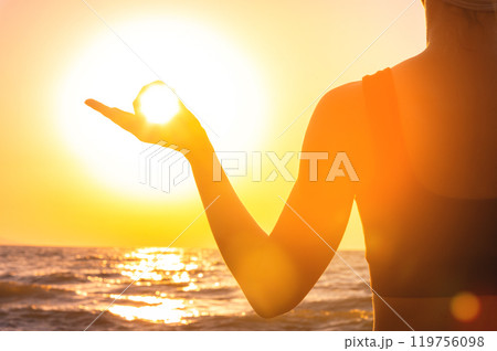 close up of man meditating with hands in gyan mudra at sunset. female hand against sun and sea, fingers showing mudra during meditation practice, calm and tranquility in nature close up of man meditating with hands in gyan mudra at sunset. female hand against sun and sea, fingers showing mudra during meditation practice, calm and tranquility in nature 119756098