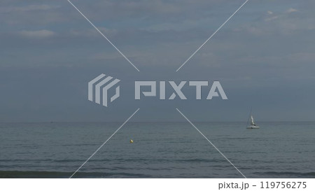 Slow-motion sailing of yacht near beach buoy 119756275