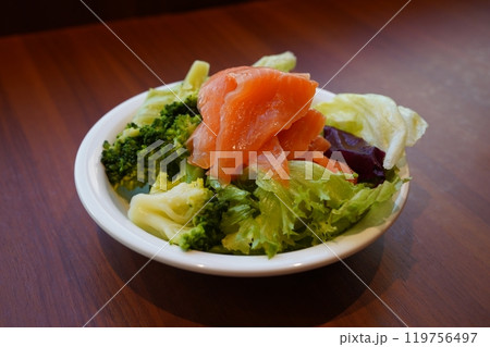 Salad with salmon and broccoli in white plate on wooden table Salad with salmon and broccoli in white plate on wooden table 119756497