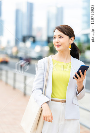 都市を背景にスマホを持つ女性 都市を背景にスマホを持つ女性 119756928