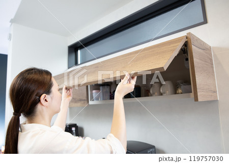 キッチン収納　ドアを開ける女性　上収納ラック 119757030