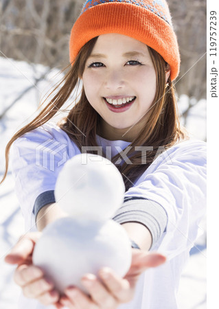 スキー場で小さい雪だるまを作って見せる若い女性 スキースノーボードイメージ スキー場で小さい雪だるまを作って見せる若い女性 スキースノーボードイメージ 119757239