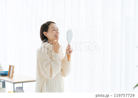 鏡で歯のチェックをする女性 119757729