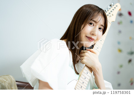 エレキギターを持つロングヘアの若い女性 119758301