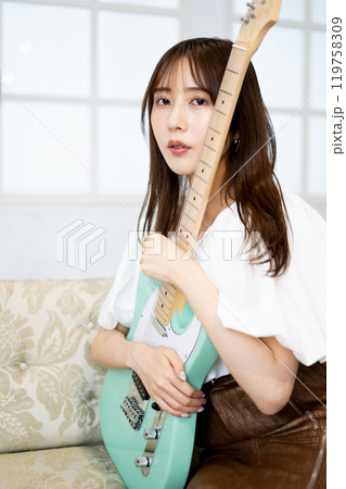 エレキギターを持つロングヘアの若い女性 エレキギターを持つロングヘアの若い女性 119758309