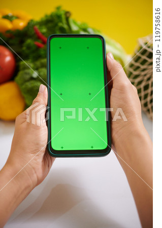 Holding Smartphone with Green Screen for Mockup Display 119758616