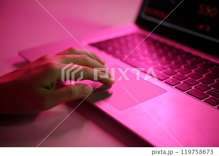 Hand Typing on Laptop with Pink Light Reflection Hand Typing on Laptop with Pink Light Reflection 119758673