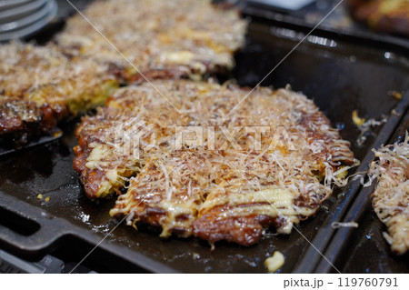 Okonomiyaki is a type of teppanyaki made with a variety of batters and toppings throughout Japan 119760791