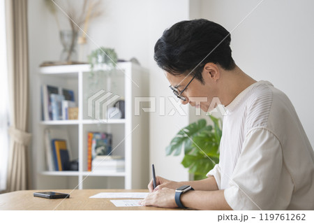 書類に記入する30代後半の男性 横小顔 書類に記入する30代後半の男性 横小顔 119761262